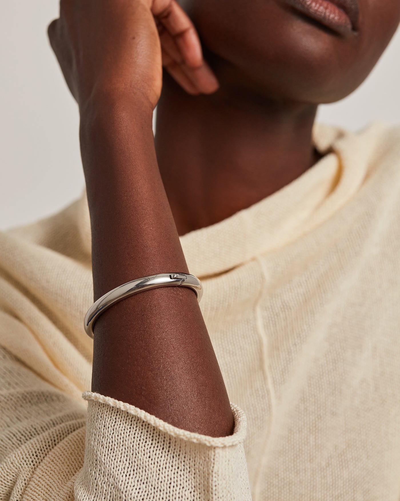 Woman wearing a large silver hoop earring with a close-up profile view.