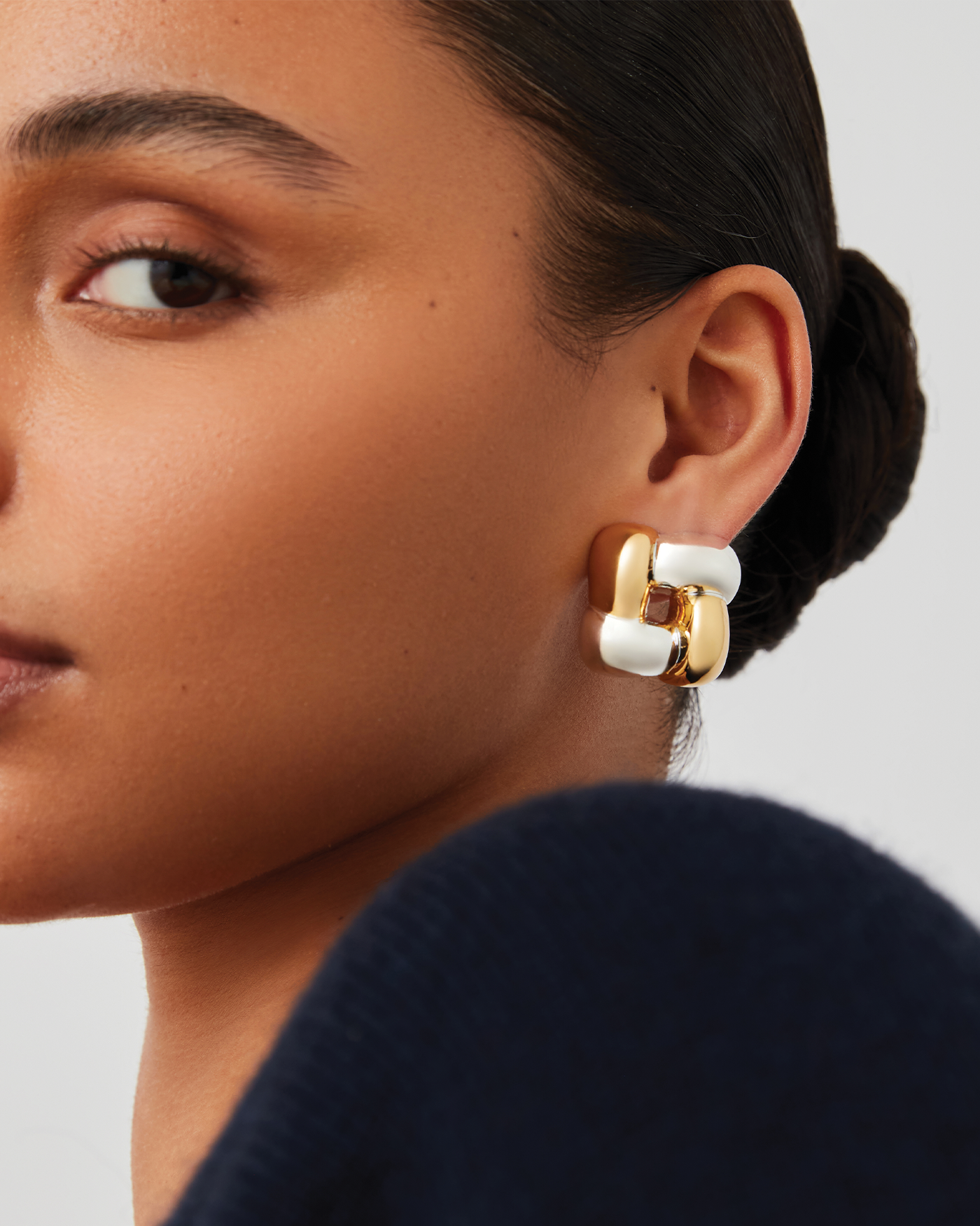 Woman wearing a large silver hoop earring with a close-up profile view.